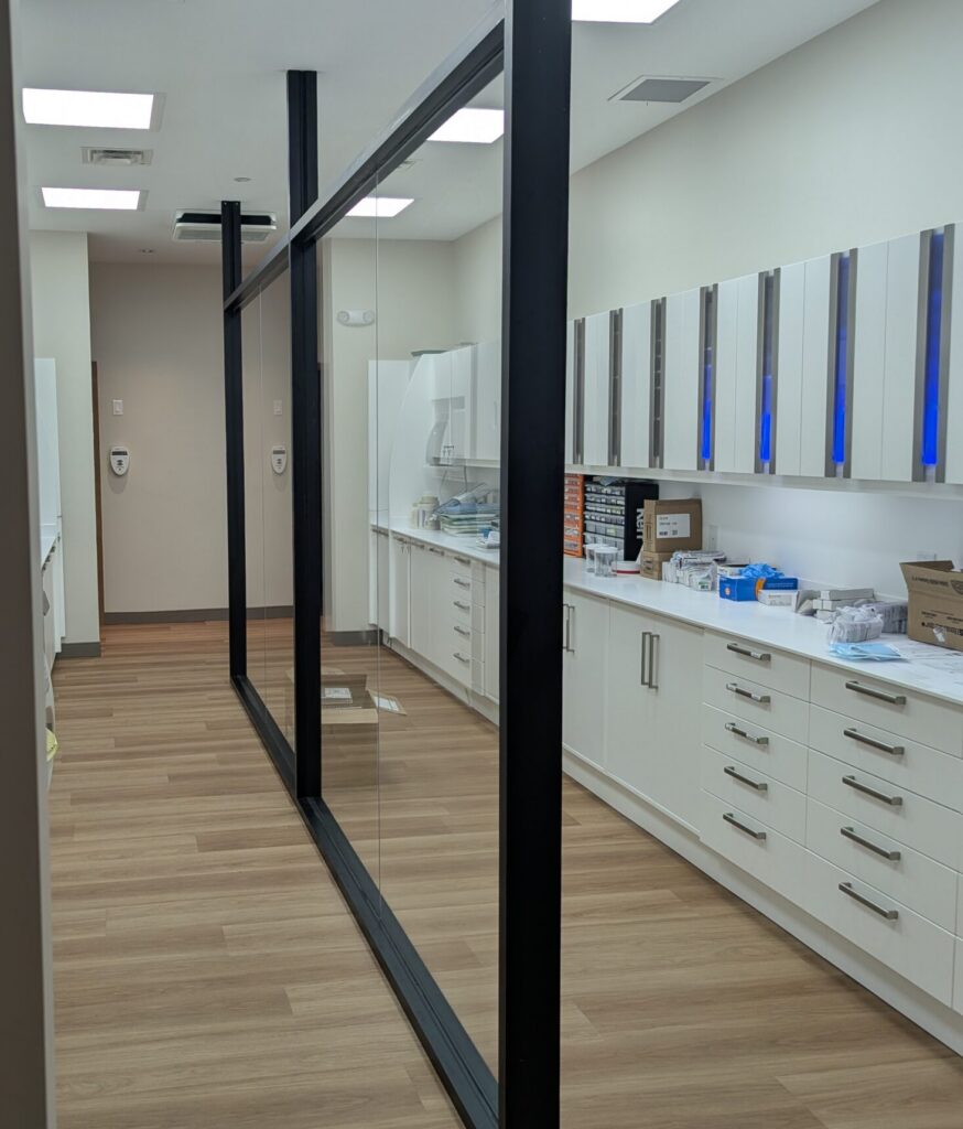 Glass partitions separating countered area from walkway, fabricated and installed by Raw Glass Inc.