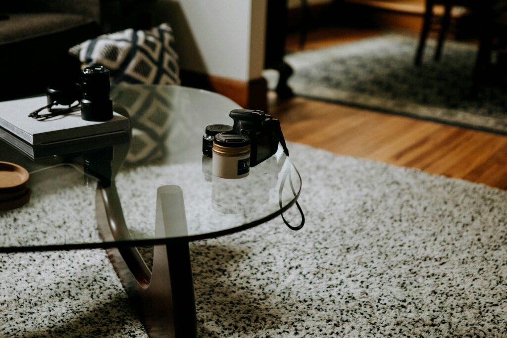 Glass tabletop on coffee table, with various stuff on it.