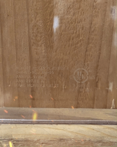 Pyran Platinum F Fire-Rated Glass Sample by Raw Glass Inc, showing UL-certification engraving and Raw Glass sticker with contact information.