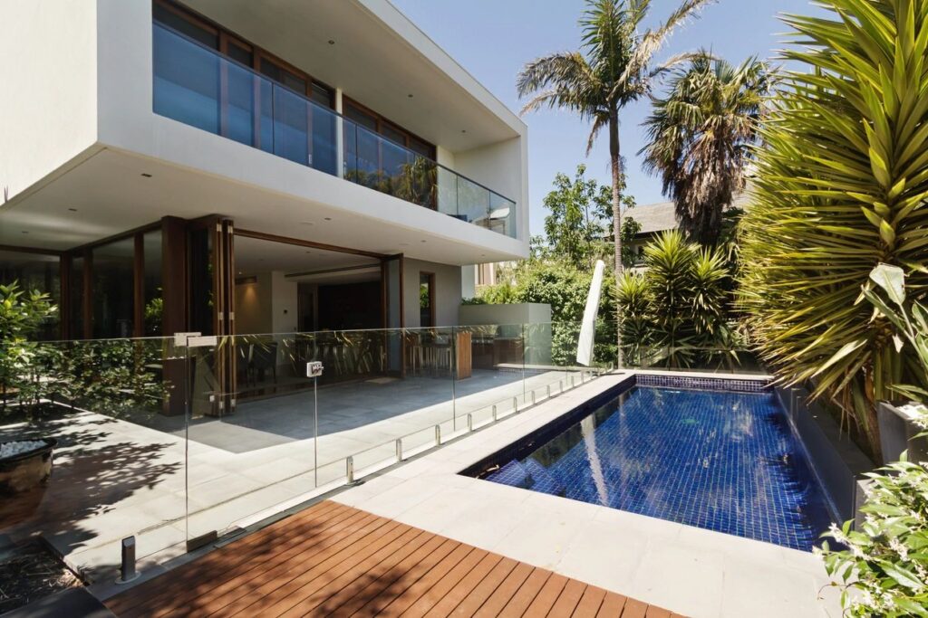 Modern house with a swimming pool protected by elegant frameless glass railing